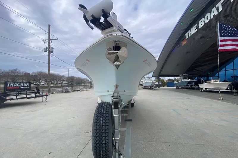 Slide: The Image of 2021 Sea Hunt Gamefish 27 boat on trailer outside dealership, American flag visible. - 8