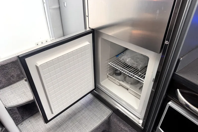 Slide: The Image of Open refrigerator in 2014 Formula 400 FX8 boat interior, showing ice and storage. - 23