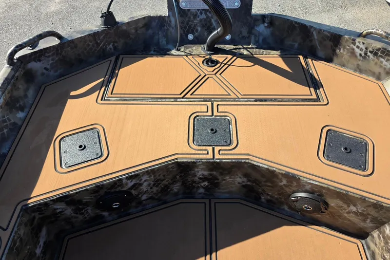 Slide: The Image of 2026 Excel Switchblade boat deck with tan non-slip surface and storage compartments. - 21