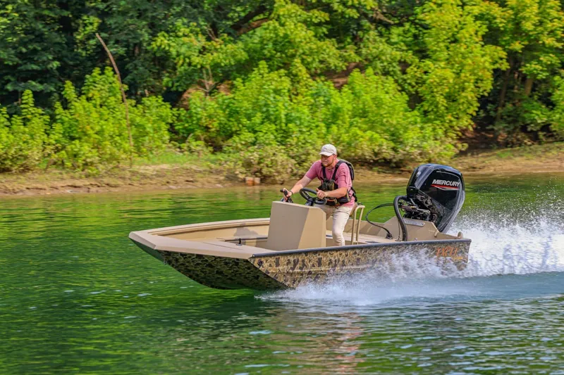 Slide: The Image of 2026 Excel Switchblade boat speeding on a lake with lush green trees in the background. - 22