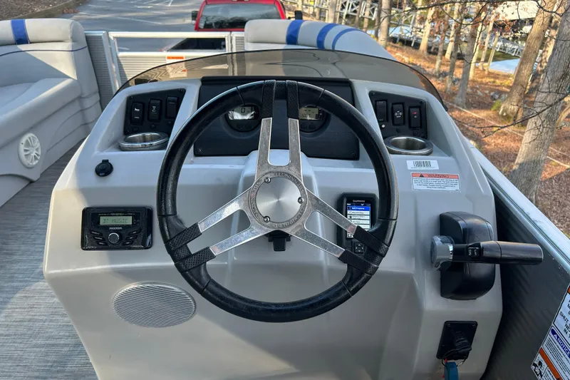 Slide: The Image of 2023 Bennington 22 SSRX boat dashboard with steering wheel and controls. - 10