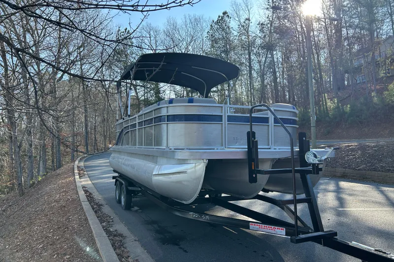 Slide: The Image of 2023 Bennington 22 SSRX pontoon boat on trailer in wooded area. - 6