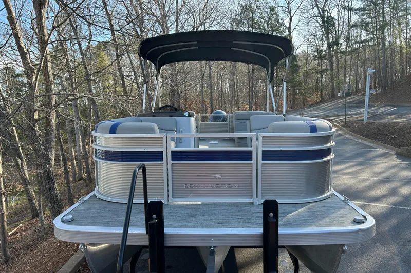 Slide: The Image of 2023 Bennington 22 SSRX pontoon boat parked on a wooded road. - 7