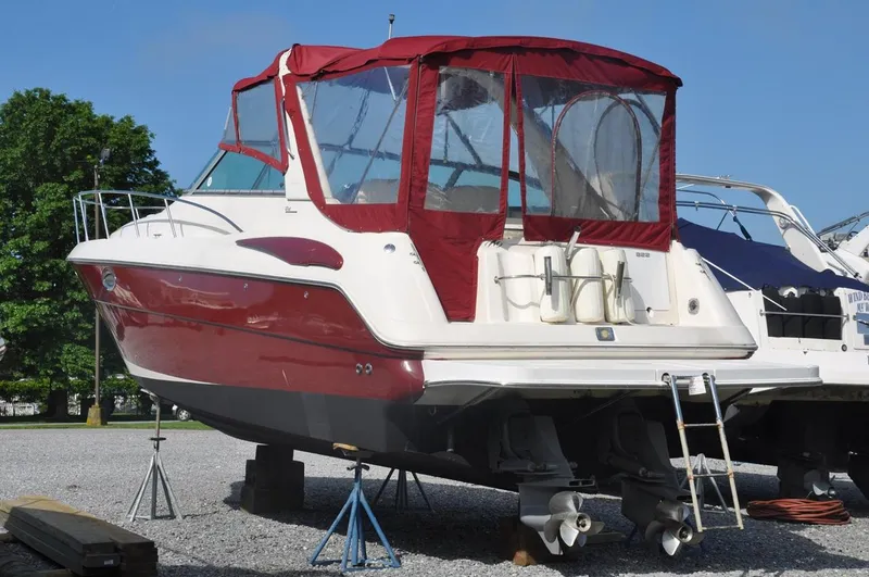 Slide: The Image of 2006 Monterey 322 Cruiser boat with red canopy on dry dock. - 2