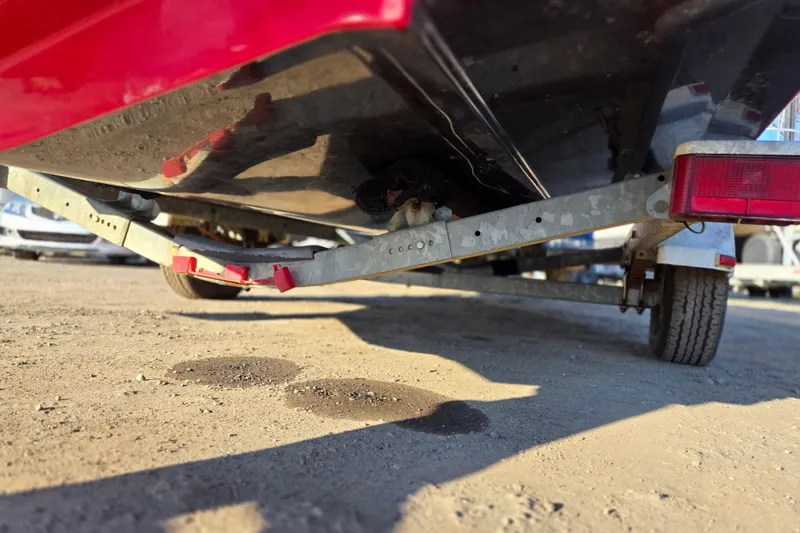 Slide: The Image of 2019 Starcraft MDX 211 O/B boat on trailer, underside view, parked on dirt. - 11