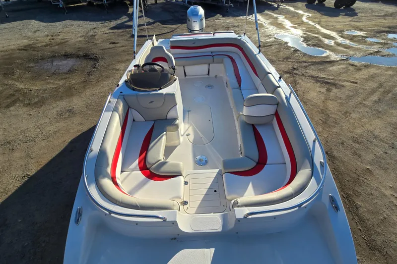 Slide: The Image of 2019 Starcraft MDX 211 O/B boat with red and white seating, parked on a dirt surface. - 18