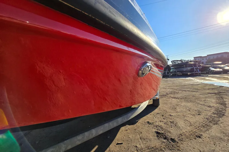 Slide: The Image of Red 2019 Starcraft MDX 211 O/B boat on a sunny day, side view. - 2