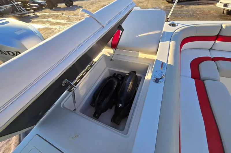Slide: The Image of 2019 Starcraft MDX 211 O/B boat storage compartment with fenders, red and white seating. - 21