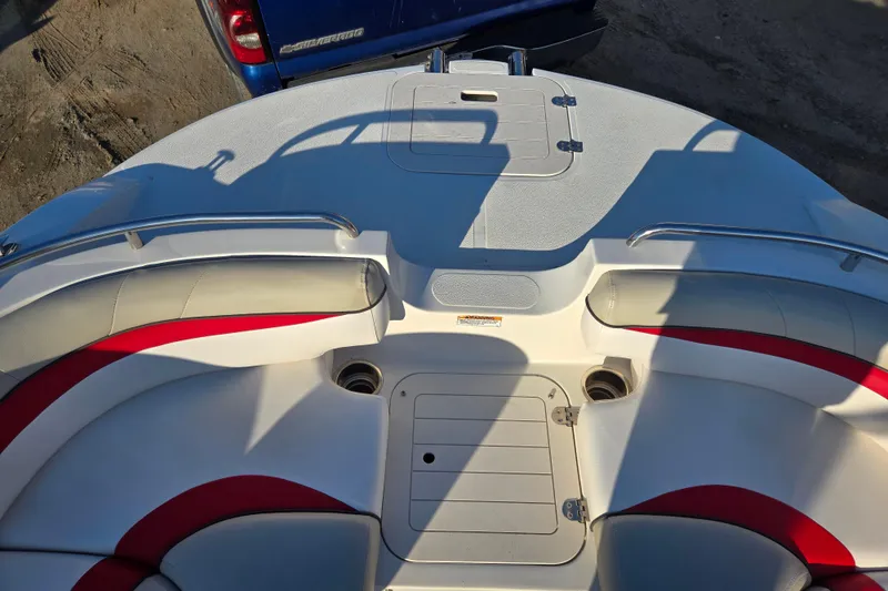 Slide: The Image of 2019 Starcraft MDX 211 O/B boat interior with red and white seating, viewed from above. - 25