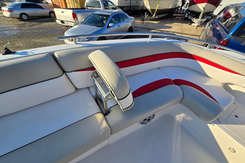 Slide: The Image of 2019 Starcraft MDX 211 O/B boat interior with red and gray seating in a parking lot. - 29