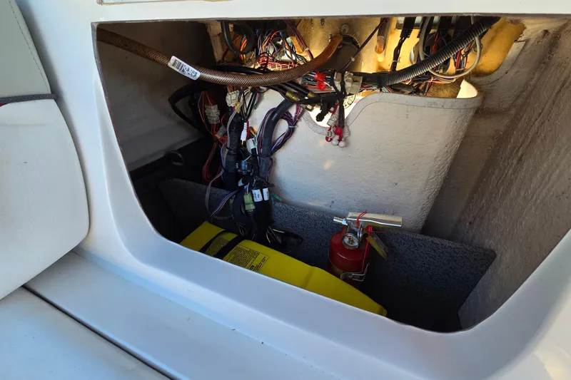 Slide: The Image of 2019 Starcraft MDX 211 O/B boat compartment with wiring, fire extinguisher, and battery. - 32