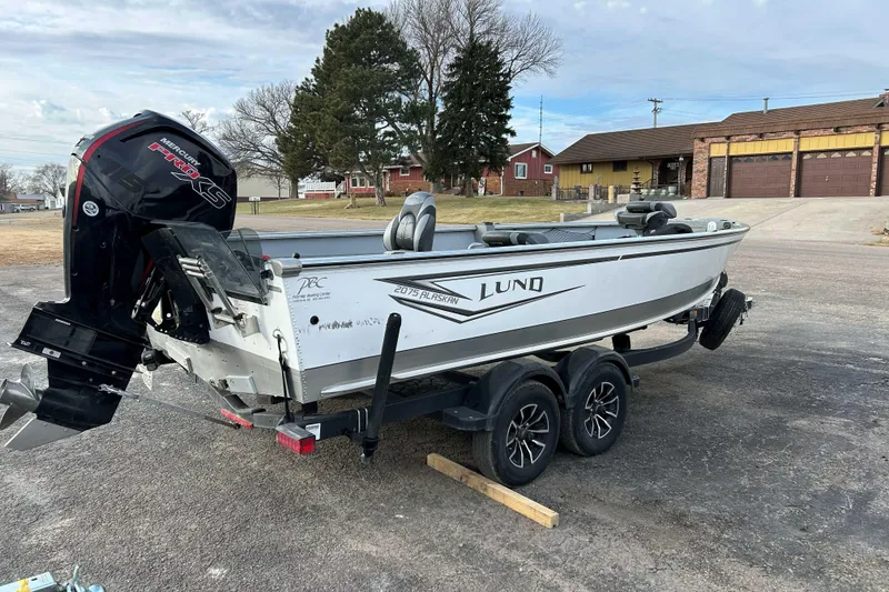 Slide: The Image of 2025 Lund 2075 Alaskan Tiller boat on trailer, parked outdoors. - 3