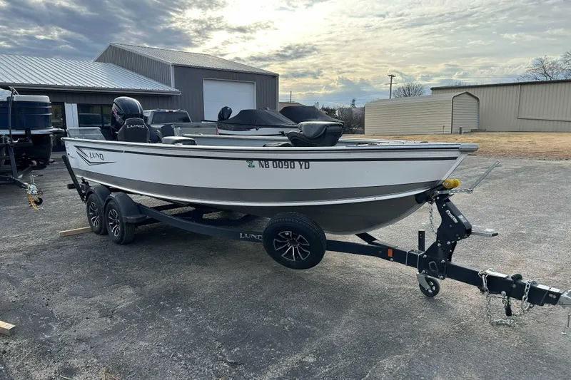 Slide: The Image of 2025 Lund 2075 Alaskan Tiller boat on trailer, parked outdoors. - 4