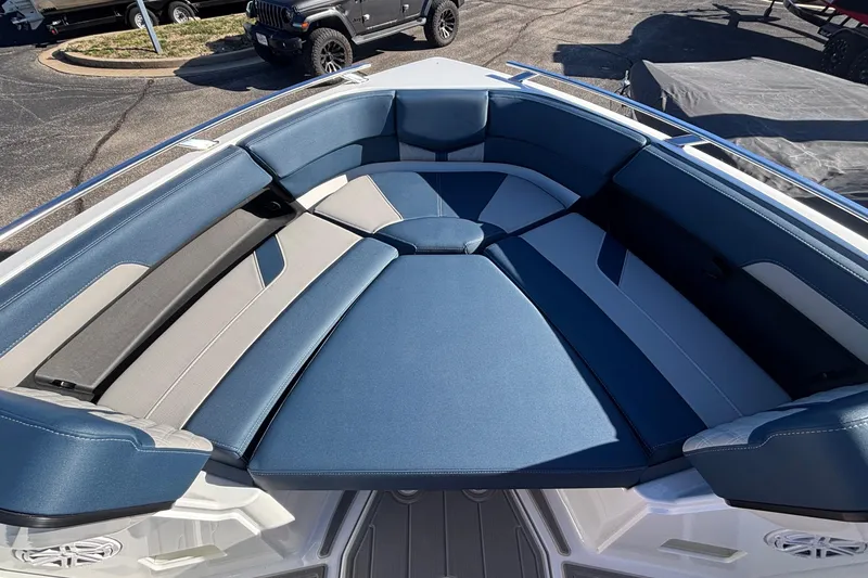 Slide: The Image of 2026 Monterey Elite 27 OB boat interior with blue and gray seating in sunlight. - 37