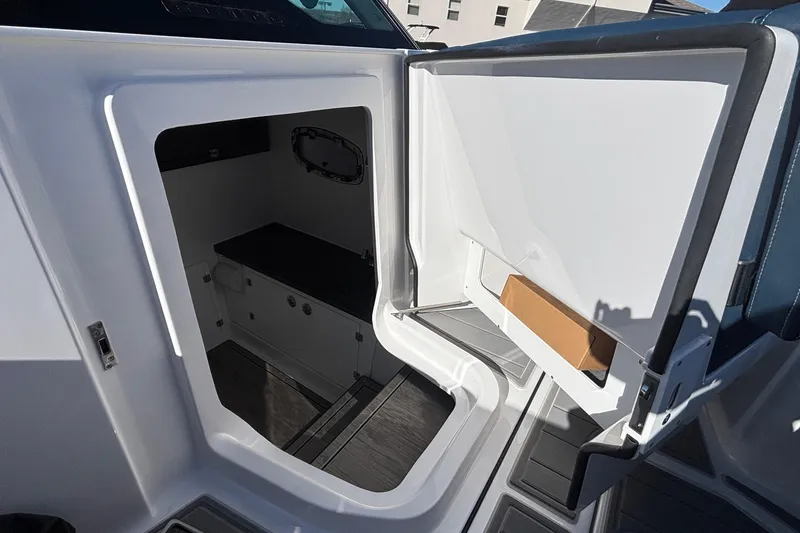 Slide: The Image of 2026 Monterey Elite 27 OB boat interior storage compartment with open door. - 45