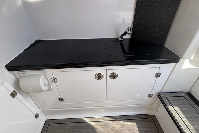 Slide: The Image of 2026 Monterey Elite 27 OB boat interior with sleek black countertop and sink. - 50