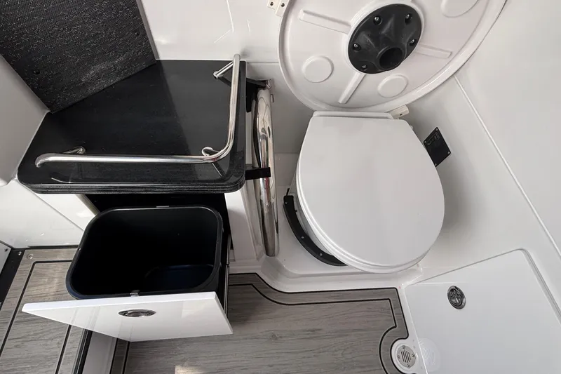 Slide: The Image of 2026 Monterey Elite 27 OB boat bathroom with toilet, sink, and storage cabinet. - 55
