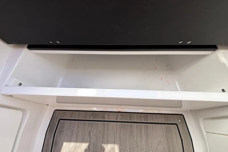 Slide: The Image of 2026 Monterey Elite 27 OB boat interior storage compartment with wood-textured flooring. - 56