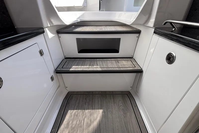 Slide: The Image of Interior steps of 2026 Monterey Elite 27 OB boat, featuring sleek design and wood finish. - 57