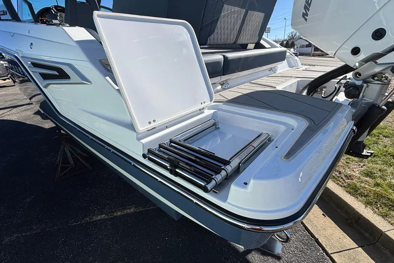 Slide: The Image of 2026 Monterey Elite 27 OB boat with open storage compartment and ladder on deck. - 65