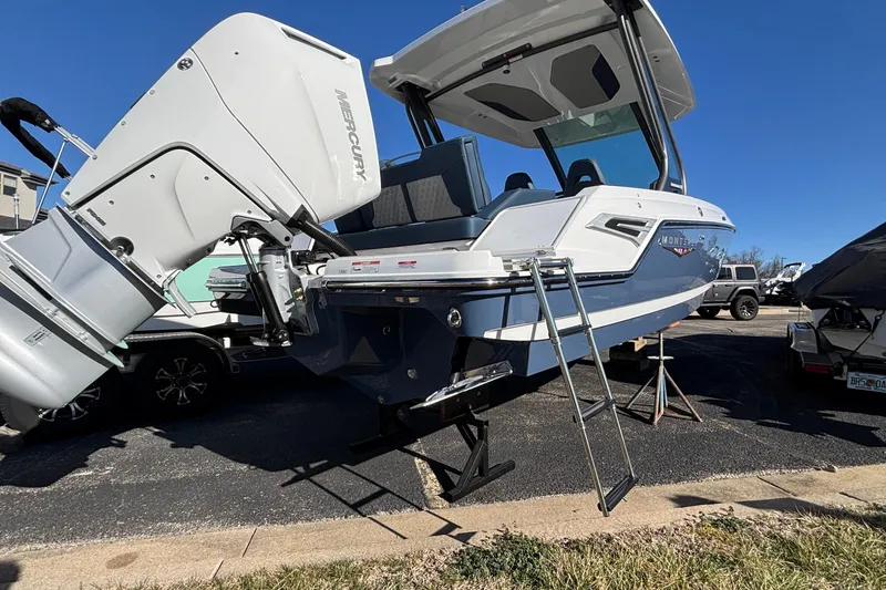 Slide: The Image of 2026 Monterey Elite 27 OB boat with Mercury outboard engine and ladder, parked outdoors. - 68