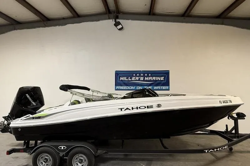 The Image of 2024 Tahoe T21 boat on trailer in showroom, Miller's Marine banner in background. - 0