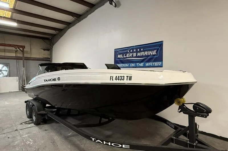 Slide: The Image of 2024 Tahoe T21 boat on trailer in indoor showroom. - 1