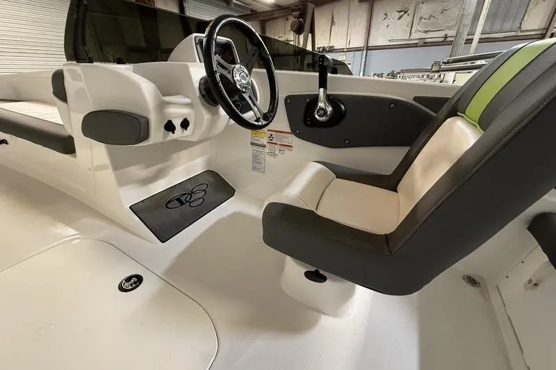 Slide: The Image of 2024 Tahoe T21 boat interior with steering wheel and seating in a showroom. - 11