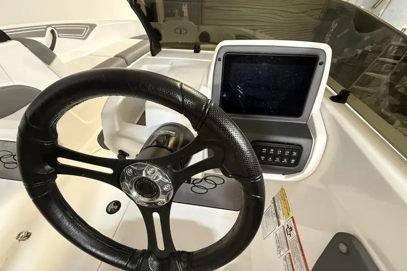 Slide: The Image of Steering wheel and dashboard of 2024 Tahoe T21 boat, featuring modern controls and display. - 13
