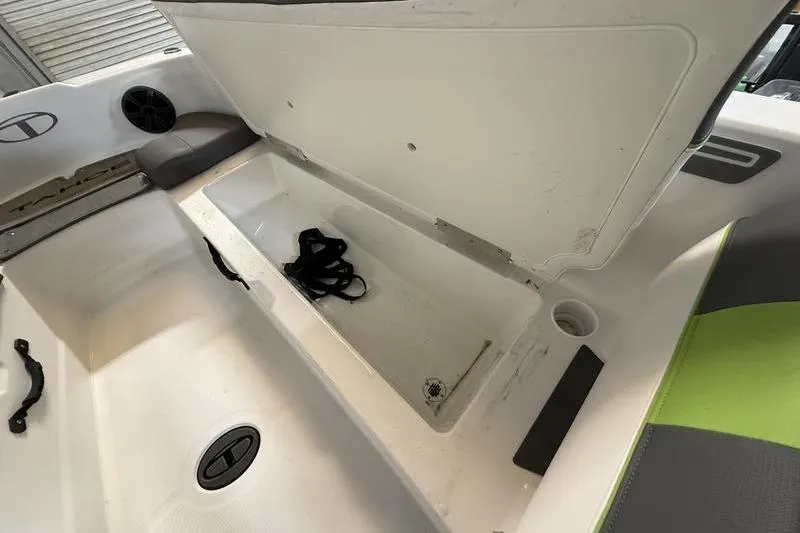 Slide: The Image of 2024 Tahoe T21 boat interior storage compartment with open lid and seating area. - 17