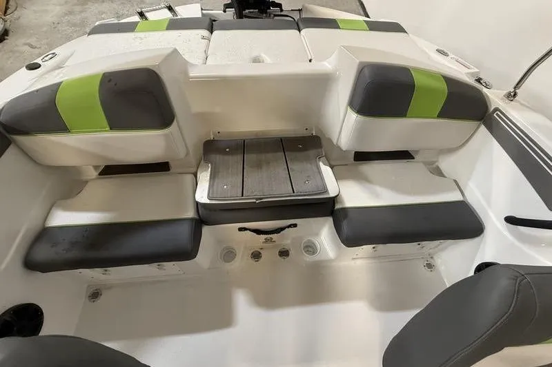 Slide: The Image of 2024 Tahoe T21 boat interior with gray and green seating, featuring a central wooden platform. - 9