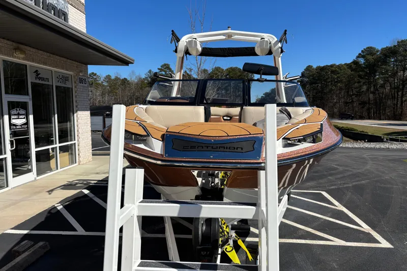 Slide: The Image of 2022 Centurion Ri245 boat displayed outside a store on a sunny day. - 1