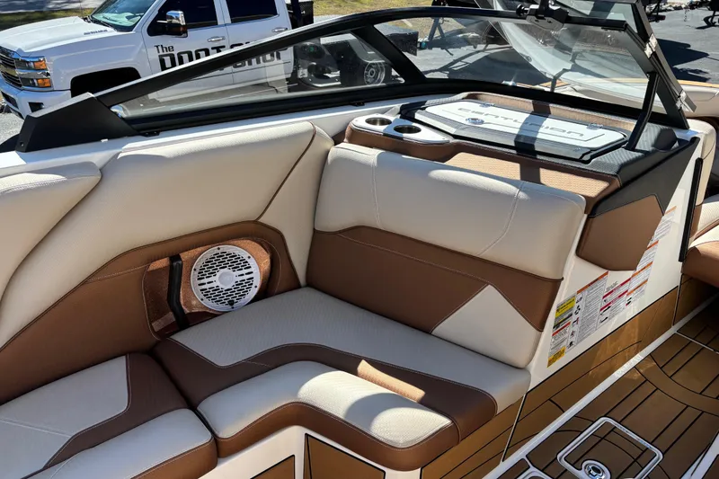 Slide: The Image of 2022 Centurion Ri245 boat interior with beige and brown seating, speaker, and cup holders. - 10