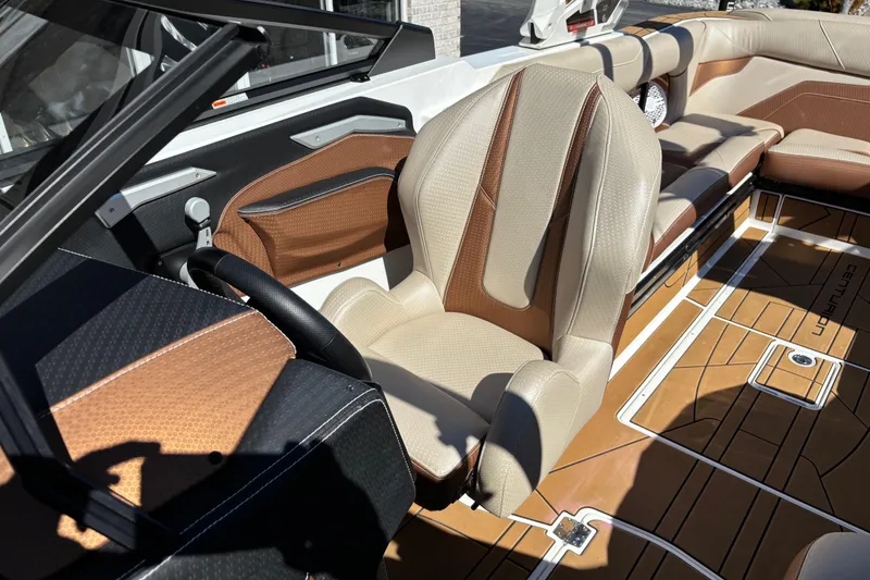 Slide: The Image of 2022 Centurion Ri245 boat interior with tan and brown leather seating and sleek design. - 9
