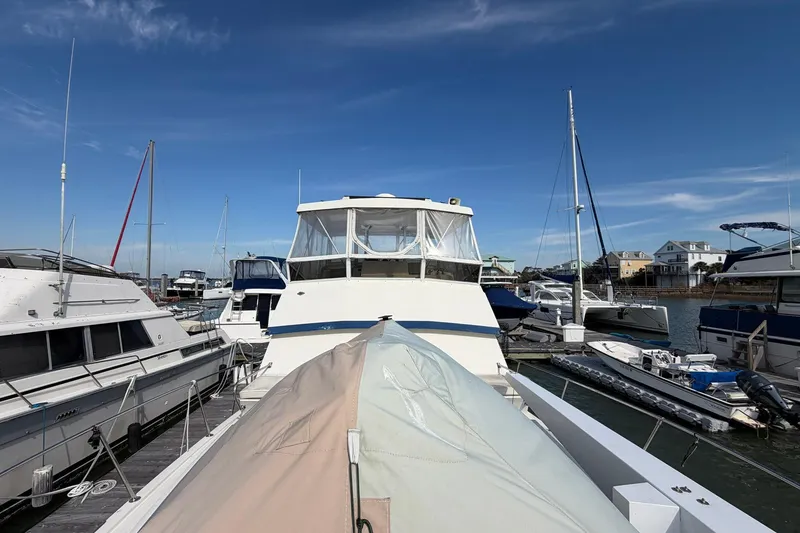 Slide: The Image of 1987 Viking 44 Motor Yacht docked at marina under clear blue sky. - 11