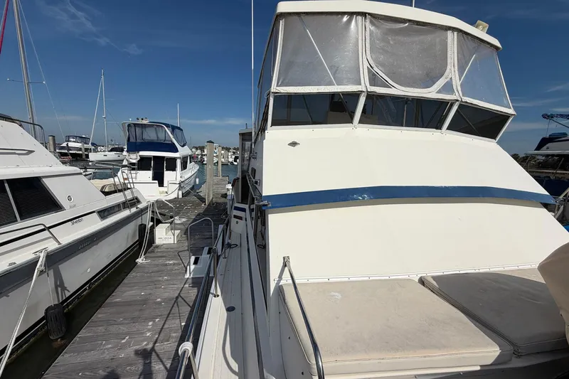 Slide: The Image of 1987 Viking 44 Motor Yacht docked at marina under clear blue sky. - 16