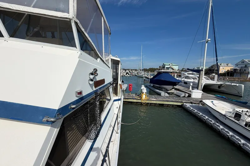 Slide: The Image of 1987 Viking 44 Motor Yacht docked at a marina with other boats under a clear blue sky. - 18