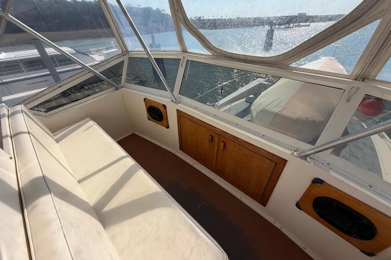 Slide: The Image of 1987 Viking 44 Motor Yacht interior with seating, wooden cabinets, and waterfront view. - 29