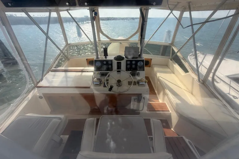 Slide: The Image of 1987 Viking 44 Motor Yacht helm with panoramic ocean view and classic controls. - 31
