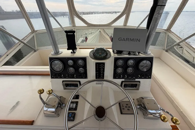 Slide: The Image of 1987 Viking 44 Motor Yacht helm with Garmin navigation, steering wheel, and control panels. - 32