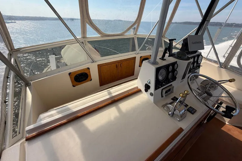 Slide: The Image of 1987 Viking 44 Motor Yacht helm with Garmin navigation, overlooking serene waters. - 34