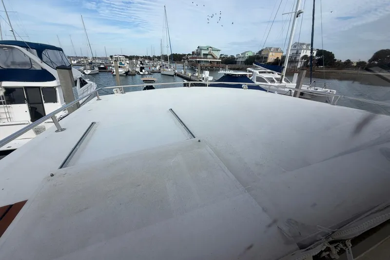 Slide: The Image of 1987 Viking 44 Motor Yacht docked in a marina, surrounded by other boats. - 36