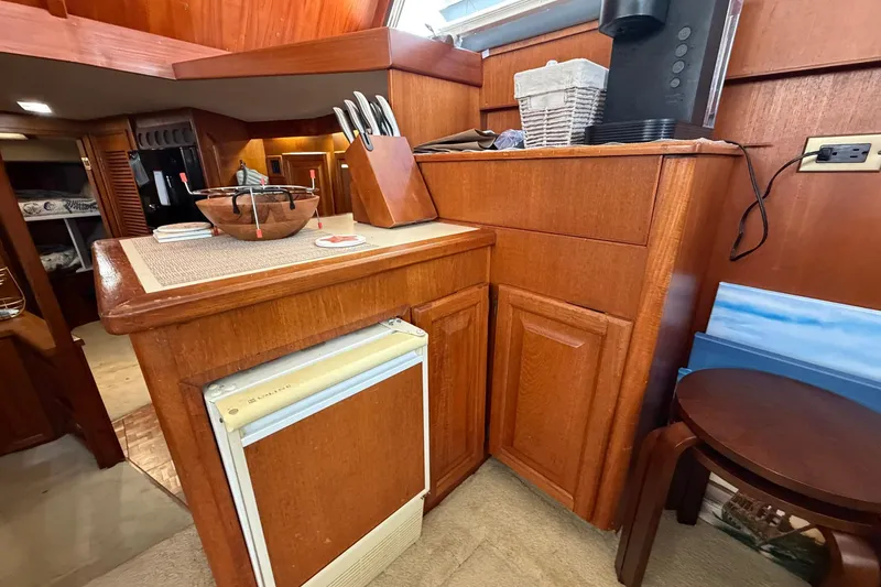 Slide: The Image of 1987 Viking 44 Motor Yacht interior with wooden cabinetry and compact kitchen area. - 46