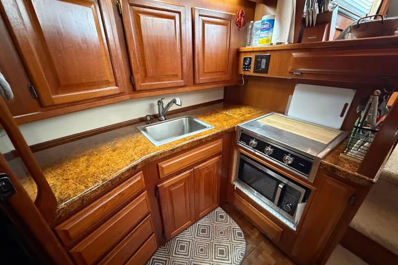 Slide: The Image of 1987 Viking 44 Motor Yacht kitchen with wood cabinets, sink, and stove. - 48