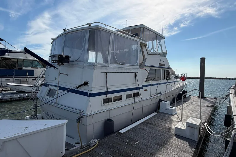 Slide: The Image of 1987 Viking 44 Motor Yacht docked at marina under clear blue sky. - 5