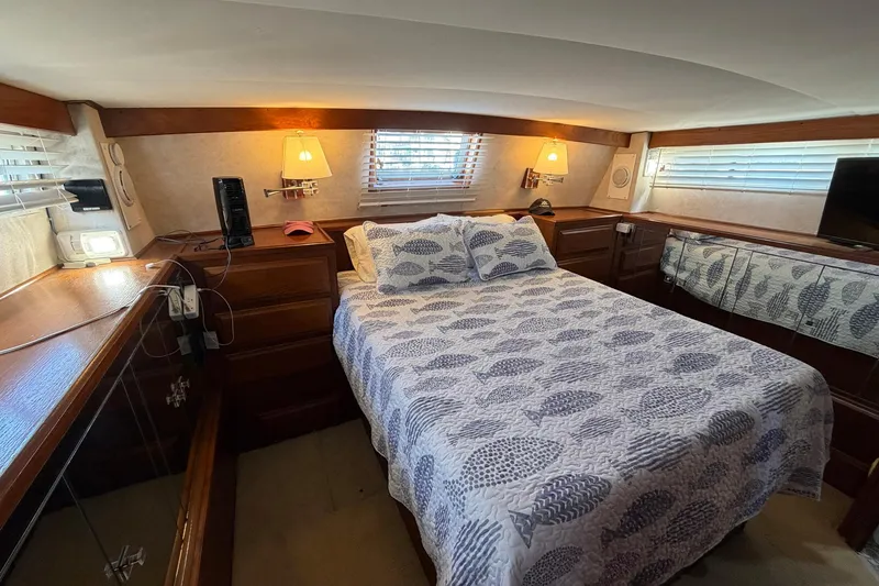 Slide: The Image of Cozy bedroom in 1987 Viking 44 Motor Yacht with patterned bedding and wooden accents. - 54
