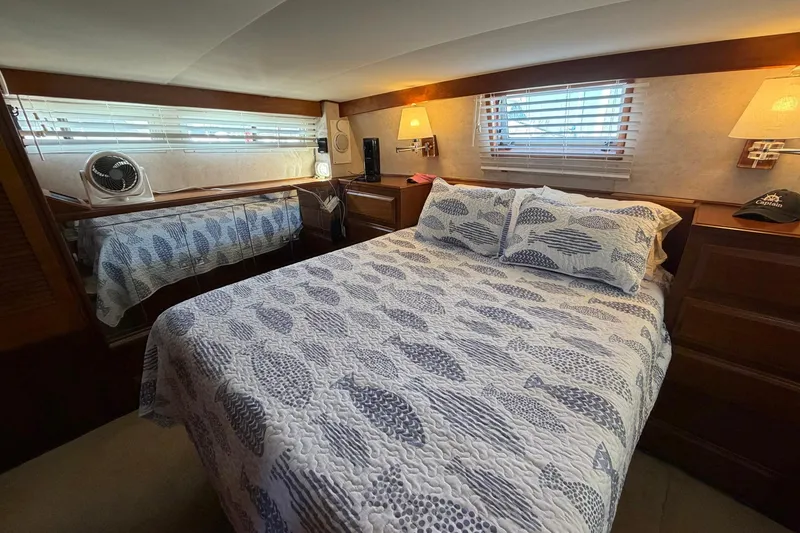 Slide: The Image of Cozy bedroom in 1987 Viking 44 Motor Yacht with nautical-themed bedding and warm lighting. - 55