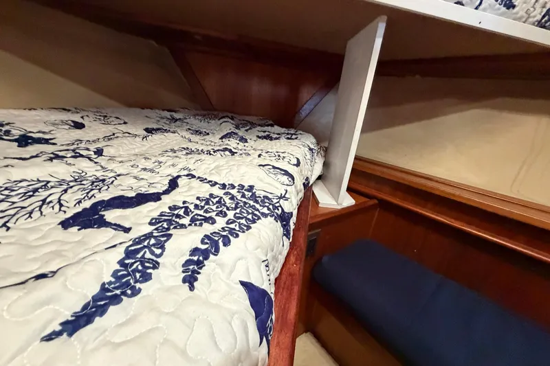 Slide: The Image of Interior of 1987 Viking 44 Motor Yacht with patterned bedding and wooden accents. - 62