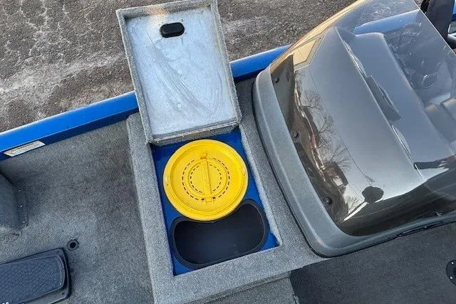 Slide: The Image of 2008 Triton TC-17 boat interior with storage compartment and yellow lid. - 11