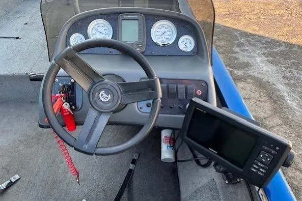 Slide: The Image of 2008 Triton TC-17 boat dashboard with steering wheel and electronic controls. - 17